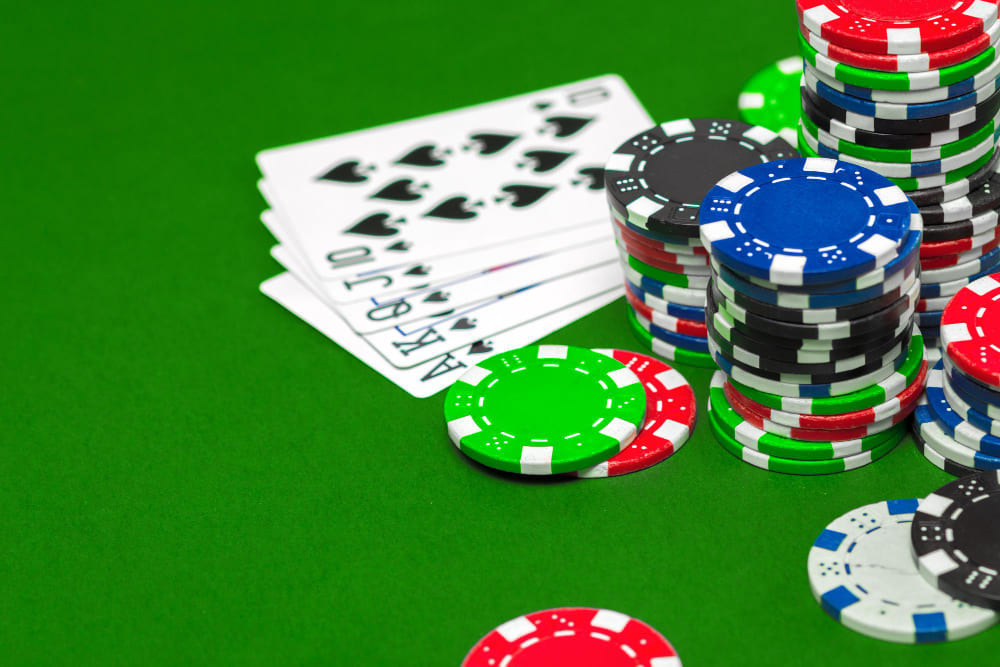 Profesionální pokerový stůl s kartami a fiktivními žetony za soumraku